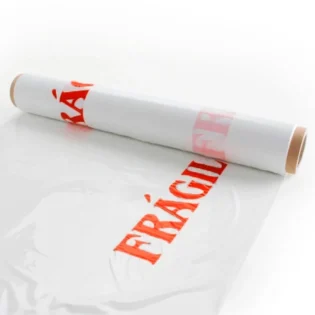 Um rolo de filme estirável personalizado com "frágil" a vermelho, a ser desenrolado.
